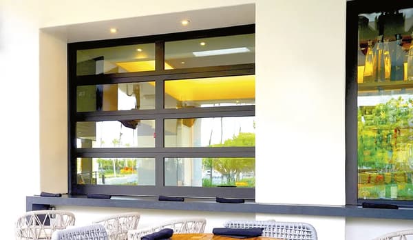 Vertical-lift garage door track conversion for low-headroom warehouse applications